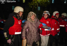 Paramédicos ayudan a una mujer evacuada de un edificio.