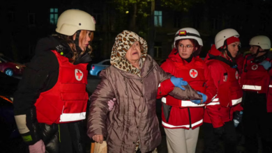 Paramédicos ayudan a una mujer evacuada de un edificio.