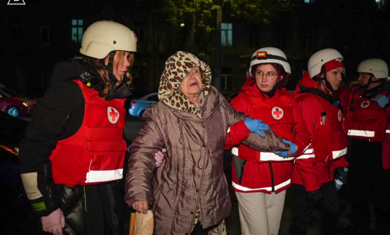 Paramédicos ayudan a una mujer evacuada de un edificio.