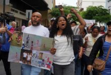 Luis Arroyo, a la izquierda, con las fotos de sus dos hijos desaparecidos, Ismael y Josué, quienes fueron detenidos por militares el 8 de diciembre. (AP Foto/César Muñoz)