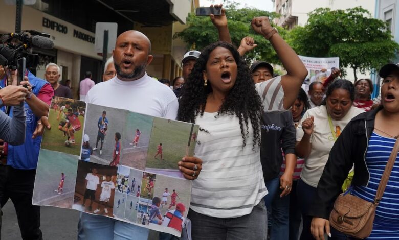 Luis Arroyo, a la izquierda, con las fotos de sus dos hijos desaparecidos, Ismael y Josué, quienes fueron detenidos por militares el 8 de diciembre. (AP Foto/César Muñoz)