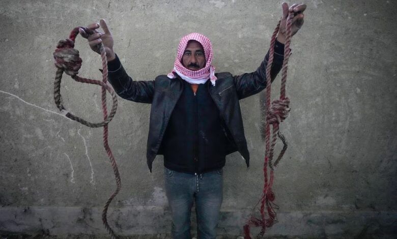 Un hombre muestra dos cuerdas atadas en forma de sogas, encontradas en la prisión militar de Saydnaya. Foto: AP/Hussein Malla