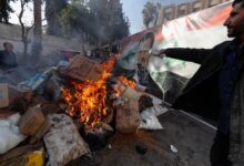 Una imagen del derrocado sirio Bashar al Assad arde en el fuego mientras un miembro sirio de las fuerzas rebeldes destruye drogas y bebidas alcohólicas encontradas en un edificio en Damasco (AP Foto/Omar Sanadiki)