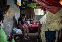 Rebeca Judith López, sentada en una cama con su nieto, Josué Jassiel García Romero, de 2 años, en Panchimalco en abril. El padre del niño fue detenido y señalado de pertenecer a una pandilla.