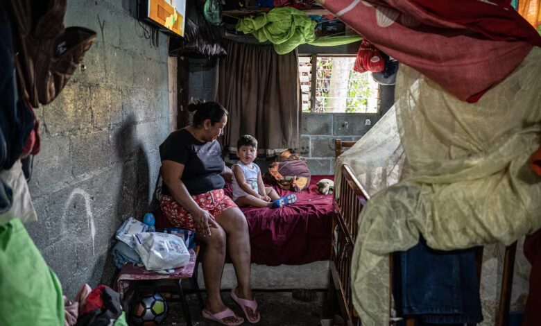 Rebeca Judith López, sentada en una cama con su nieto, Josué Jassiel García Romero, de 2 años, en Panchimalco en abril. El padre del niño fue detenido y señalado de pertenecer a una pandilla.