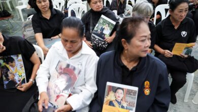 Varias personas sostienen fotografías de la princesa Bajrakitiyabha de Tailandia.