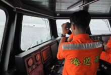 En esta imagen, distribuida por la Guardia Costera de Taiwán, un efectivo vigila un buque de la marina de China