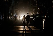 Personas caminan por una calle sin electricidad, en La Habana
