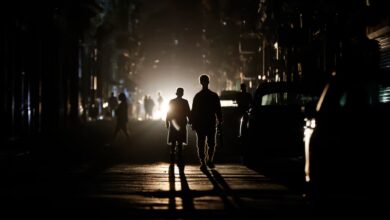 Personas caminan por una calle sin electricidad, en La Habana