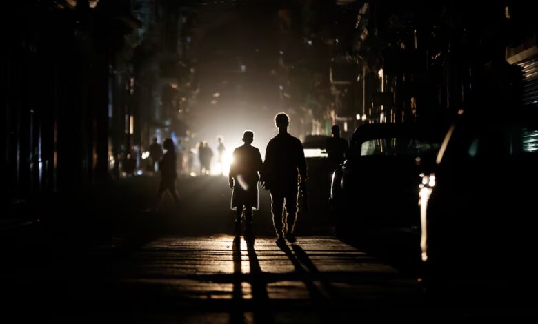 Personas caminan por una calle sin electricidad, en La Habana