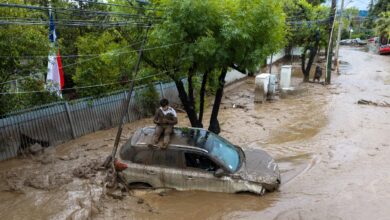 Por qué se produjo el aluvión en Santiago de Chile y qué ocurrió con los desagües Las precipitaciones fueron uno de los principales factores que desencadenaron el desastre. Entre el lunes y el martes, algunos sectores de la Región Metropolitana registraron más de 140 milímetros de lluvia, mientras que en otras zonas las mediciones rondaron los 60 milímetros. La tierra ya estaba saturada y perdió capacidad para absorber nuevas precipitaciones, lo que aceleró el escurrimiento del agua hacia las zonas más bajas. “El suelo está absolutamente mojado, no da, está totalmente saturado”, explicó Catalina San Martín, alcaldesa de Las Condes. A las lluvias se sumó otro fenómeno meteorológico. Según explicó Pablo Allard, decano de la Facultad de Arquitectura y Arte de la Universidad del Desarrollo, a ADN Radio, la isoterma cero se ubicó a una altura anormalmente elevada. Esto provocó que parte de las precipitaciones que habitualmente caen en forma de nieve en la montaña llegaran como agua líquida. Como consecuencia, aumentó rápidamente el volumen que descendió por las quebradas. Sin embargo, uno de los factores decisivos fue la obstrucción de dos ductos paralelos que debían canalizar el agua fuera del área urbana. El delegado presidencial de la Región Metropolitana, Germán Codina, explicó que los conductos habrían quedado bloqueados por basura y escombros. Al no poder continuar su recorrido, el agua desbordó la Quebrada Honda y avanzó hacia las calles. Las precipitaciones también provocaron crecidas de los ríos Mapocho y Maipo. En Talagante, el desborde del Maipo generó inundaciones que afectaron a sectores con viviendas precarias. El efecto de los incendios forestales y las obras de prevención que no llegaron a instalarse La magnitud del aluvión también estuvo relacionada con los incendios forestales que afectaron la precordillera de Santiago durante el verano. El fuego destruyó parte de la vegetación que contribuía a mantener estable el suelo. Sin esa cobertura, las lluvias encontraron grandes cantidades de tierra y sedimentos sueltos que fueron arrastrados pendiente abajo. Este factor agravó la fuerza destructiva de la corriente y aumentó el volumen de barro que terminó acumulándose en las calles. El riesgo ya había sido identificado por las autoridades chilenas. El Ministerio de Obras Públicas y el Servicio Nacional de Prevención y Respuesta ante Desastres (SENAPRED) tenían previsto instalar mallas de contención para reducir el arrastre de materiales desde las quebradas. Sin embargo, esa infraestructura preventiva todavía no estaba operativa cuando ocurrió el aluvión. La situación abrió interrogantes sobre las medidas de prevención y la capacidad de respuesta ante lluvias extremas, especialmente en sectores urbanos próximos a las laderas de la cordillera. La alcaldesa San Martín defendió las tareas realizadas antes del temporal. “El trabajo preventivo se hizo, esta lluvia era absolutamente inesperada, es la naturaleza”, sostuvo.
