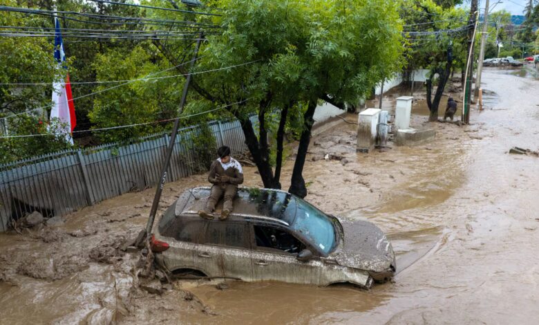 Por qué se produjo el aluvión en Santiago de Chile y qué ocurrió con los desagües Las precipitaciones fueron uno de los principales factores que desencadenaron el desastre. Entre el lunes y el martes, algunos sectores de la Región Metropolitana registraron más de 140 milímetros de lluvia, mientras que en otras zonas las mediciones rondaron los 60 milímetros. La tierra ya estaba saturada y perdió capacidad para absorber nuevas precipitaciones, lo que aceleró el escurrimiento del agua hacia las zonas más bajas. “El suelo está absolutamente mojado, no da, está totalmente saturado”, explicó Catalina San Martín, alcaldesa de Las Condes. A las lluvias se sumó otro fenómeno meteorológico. Según explicó Pablo Allard, decano de la Facultad de Arquitectura y Arte de la Universidad del Desarrollo, a ADN Radio, la isoterma cero se ubicó a una altura anormalmente elevada. Esto provocó que parte de las precipitaciones que habitualmente caen en forma de nieve en la montaña llegaran como agua líquida. Como consecuencia, aumentó rápidamente el volumen que descendió por las quebradas. Sin embargo, uno de los factores decisivos fue la obstrucción de dos ductos paralelos que debían canalizar el agua fuera del área urbana. El delegado presidencial de la Región Metropolitana, Germán Codina, explicó que los conductos habrían quedado bloqueados por basura y escombros. Al no poder continuar su recorrido, el agua desbordó la Quebrada Honda y avanzó hacia las calles. Las precipitaciones también provocaron crecidas de los ríos Mapocho y Maipo. En Talagante, el desborde del Maipo generó inundaciones que afectaron a sectores con viviendas precarias. El efecto de los incendios forestales y las obras de prevención que no llegaron a instalarse La magnitud del aluvión también estuvo relacionada con los incendios forestales que afectaron la precordillera de Santiago durante el verano. El fuego destruyó parte de la vegetación que contribuía a mantener estable el suelo. Sin esa cobertura, las lluvias encontraron grandes cantidades de tierra y sedimentos sueltos que fueron arrastrados pendiente abajo. Este factor agravó la fuerza destructiva de la corriente y aumentó el volumen de barro que terminó acumulándose en las calles. El riesgo ya había sido identificado por las autoridades chilenas. El Ministerio de Obras Públicas y el Servicio Nacional de Prevención y Respuesta ante Desastres (SENAPRED) tenían previsto instalar mallas de contención para reducir el arrastre de materiales desde las quebradas. Sin embargo, esa infraestructura preventiva todavía no estaba operativa cuando ocurrió el aluvión. La situación abrió interrogantes sobre las medidas de prevención y la capacidad de respuesta ante lluvias extremas, especialmente en sectores urbanos próximos a las laderas de la cordillera. La alcaldesa San Martín defendió las tareas realizadas antes del temporal. “El trabajo preventivo se hizo, esta lluvia era absolutamente inesperada, es la naturaleza”, sostuvo.
